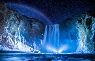 冬のアイスランドの凍った滝と星空。