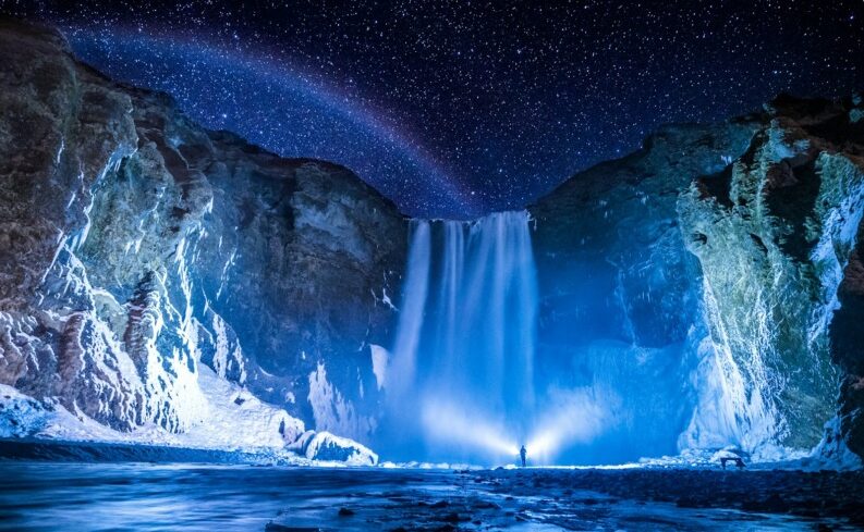 冬のアイスランドの凍った滝と星空。