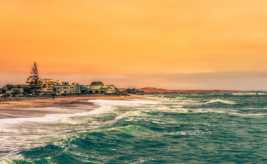 body of water near city buildings during sunset
